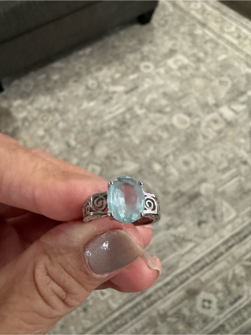 Light blue oval cut gemstone in decorative scrolling set sterling silver size 6